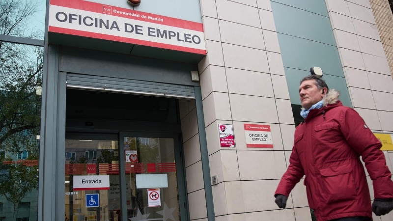 Una persona camina frente a la entrada de una oficina de empleo en Madrid, a 4 de diciembre de 2023