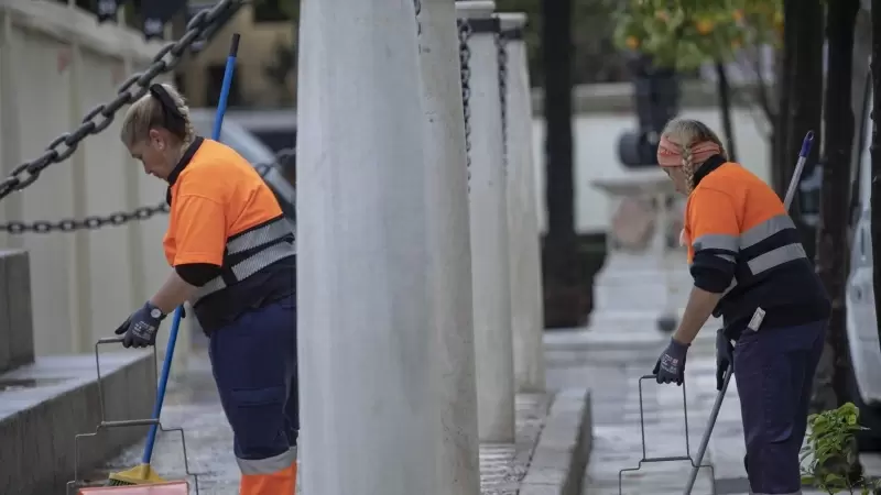 Dos trabajadoras de Lipasam realizado su trabajo en la Plaza Nueva. A 15 de diciembre de 2022, en Sevilla.