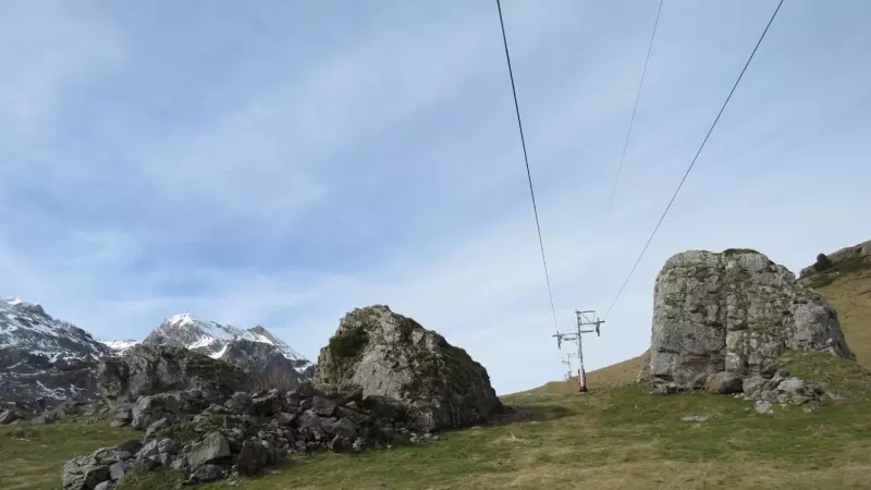 Uno de los telesillas de Candanchú perfila su paradójica estampa en un invierno sin nieve en el Pirineo.