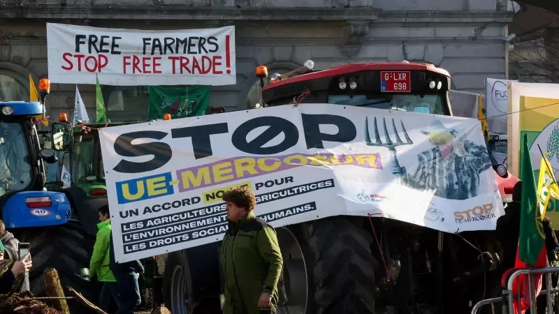 Un hombre camina junto a tractores y pancartas de la protesta de agricultores en Parlamento Europeo en Bruselas el 1 de febrero.