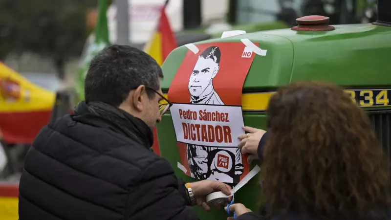 Dos manifestantes colocan un cartel contra el presidente del Gobierno mientras protestan en Ciudad Real para reclamar una agricultura más rentable que les permita hacer sostenibles en el futuro sus explotaciones agrarias y ganaderas.