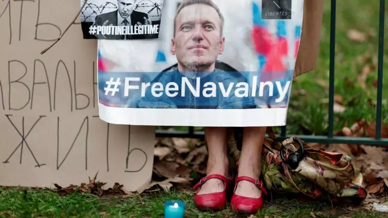 Una mujer sostiene un cartel con un retrato del líder de la oposición rusa Alexei Navalni tras su muerte, en la embajada rusa en París, a 16 de febrero de 2024.