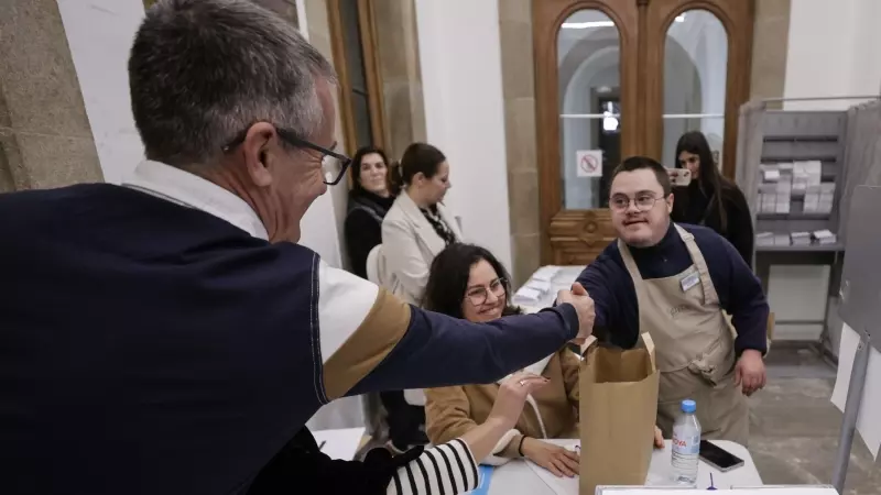 El Quiosco Down, un céntrico bar de A Coruña en el que trabajan personas con síndrome de Down, ha entregado de la mano de Adrián (c, en la imagen), uno de sus camareros, bocadillos de calamares en varias mesas electorales de la ciudad coruñesa.