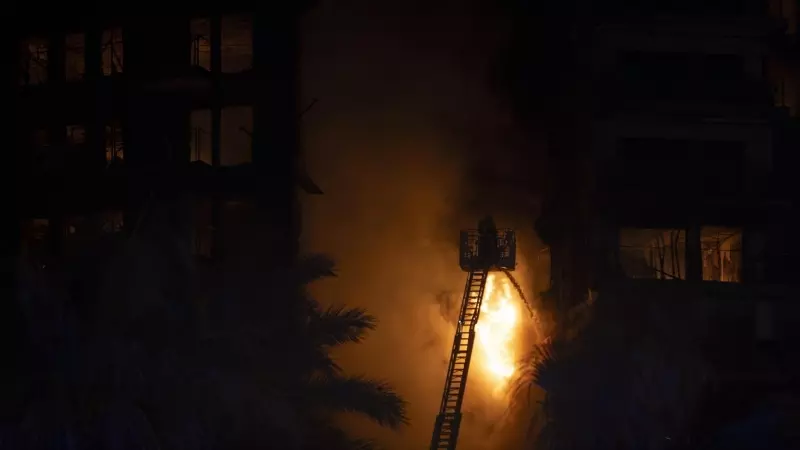 Un bombero trata de apagar el edificio en llamas del incendio del edificio de València.