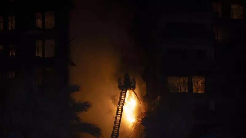 Un bombero trata de apagar las llamas del edificio de 14 plantas que ardió el jueves València.
