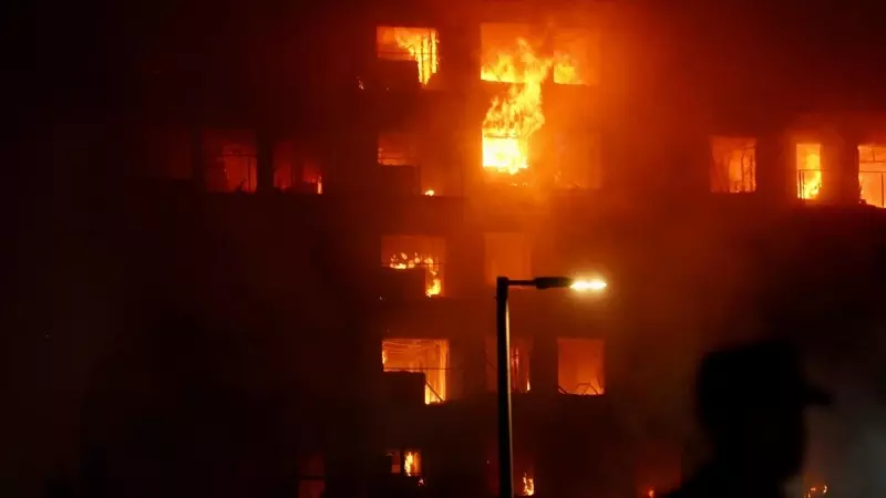 Un agente observa el edificio en llamas, en el barrio de Campanar, a 22 de febrero de 2024, en Valencia, Comunidad Valenciana (España).