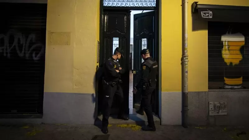 Dos agentes de Policía Nacional a las puertas de un edificio.