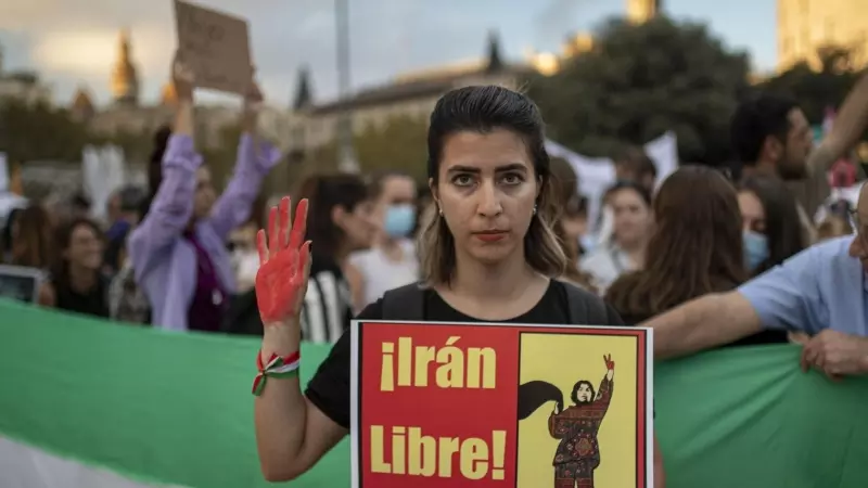 Una joven sujeta un cartel en el que pone el estribillo de la canción de 'Mujer, vida, libertad' de Hajipour, durante la manifestación en Barcelona contra el régimen Iraní tras la muerte de Mahsa Amini, el 15 de octubre de 2022, en Barcelona (España).