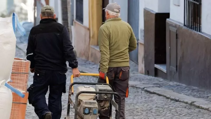 Dos trabajadores trasladan un generador a una obra en una casa en la localidad malagueña de Ronda. REUTERS/Jon Nazca