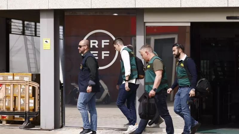 Un agente de la Europol y varios agentes de la Unidad Central Operativa (UCO) de la Guardia Civil salen de la Real Federación Española de Fútbol (RFEF), a 20 de marzo de 2024.