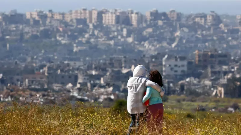 Dos personas se abrazan y observan Gaza cerca de la frontera entre Israel y el enclave, el 23 de marzo de 2024.