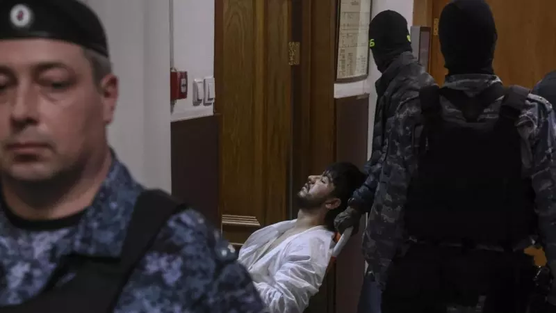 La policía rusa custodia a uno de los sospechosos del atentado durante el juicio.