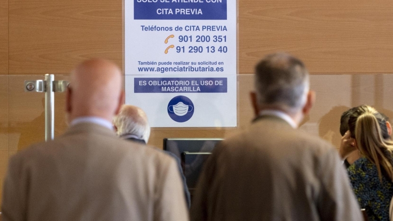 Varias personas esperan para ser atendidas en el interior de las oficinas de la Administración de la Agencia Tributaria de Madrid-Guzmán el Bueno, a 25 de mayo de 2023, en Madrid.
