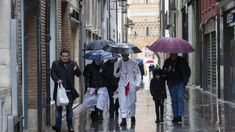 Varias personas caminando bajo la lluvia en Teruel, a 31 de marzo de 2024