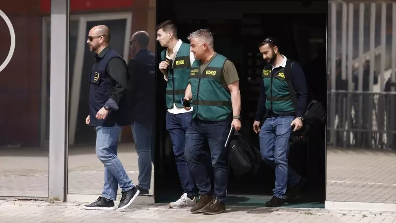 Un agente de la Europol y varios agentes de la Unidad Central Operativa de la Guardia Civil salen de la Real Federación Española de Fútbol, a 20 de marzo de 2024, en Madrid.