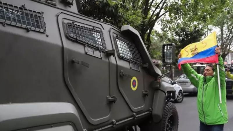 Un hombre exhibe una bandera mientras pasa un vehículo blindado donde es trasladado el exvicepresidente ecuatoriano Jorge Glas