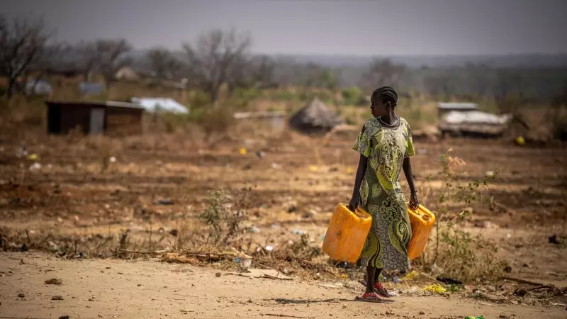 Una mujer camina por la carretera con bidones de agua, a 26 de enero de 2024 en Sudán del Sur, Juba.