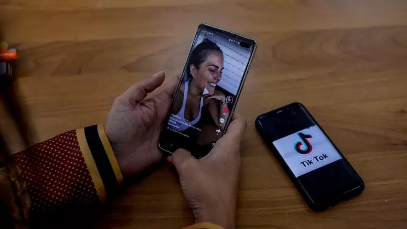 Una persona mira en su móvil el vídeo de una joven en la red musical Tik Tok