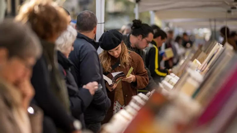 Varias personas miran libros en un puesto durante el día de Sant Jordi 2024, a 23 de abril de 2024, en Barcelona.