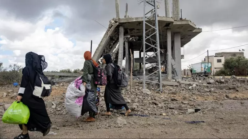 Varias mujeres palestinas caminan descalzas y cargan sus pertenencias después de la orden de evacuación emitida por el Ejército israelí, en Rafah, a 6 de mayo de 2024.