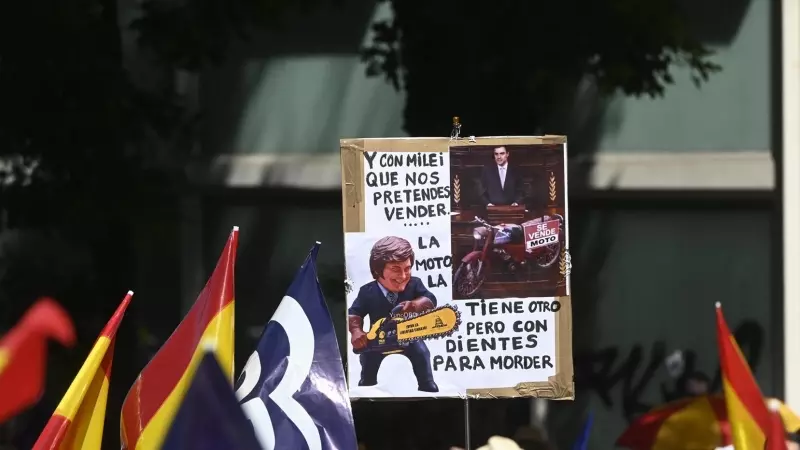 Una persona sujeta un cartel de protesta durante una manifestación del PP, en la Puerta de Alcalá, a 26 de mayo de 2024, en Madrid.