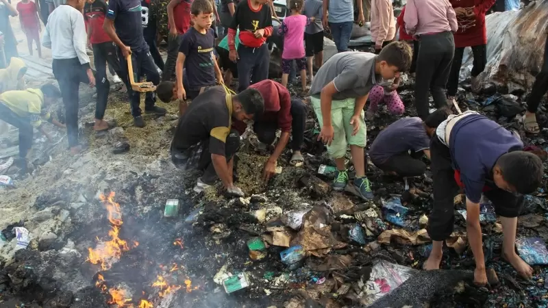 Adultos y niños buscando entre los escombros en un campamento de Rafah, después de los ataques de Israel, a 27 de mayo de 2024.