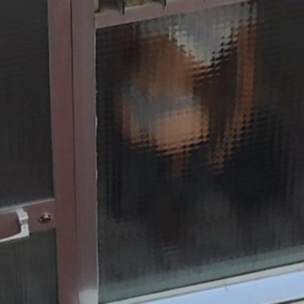 Una mujer se cambia de ripa interior en la puerta de un narcopiso en el distrito de Villaverde, Madrid.
