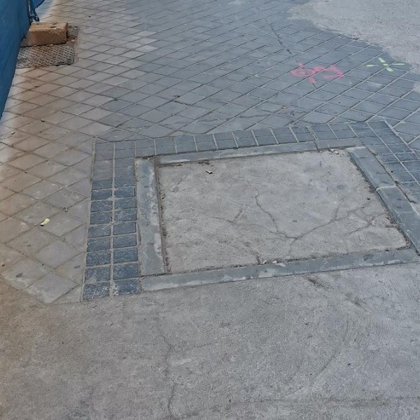 Alcorque sellado por cemento junto a las obras de la Calle Comercio, en Menéndez Pelayo, Madrid.