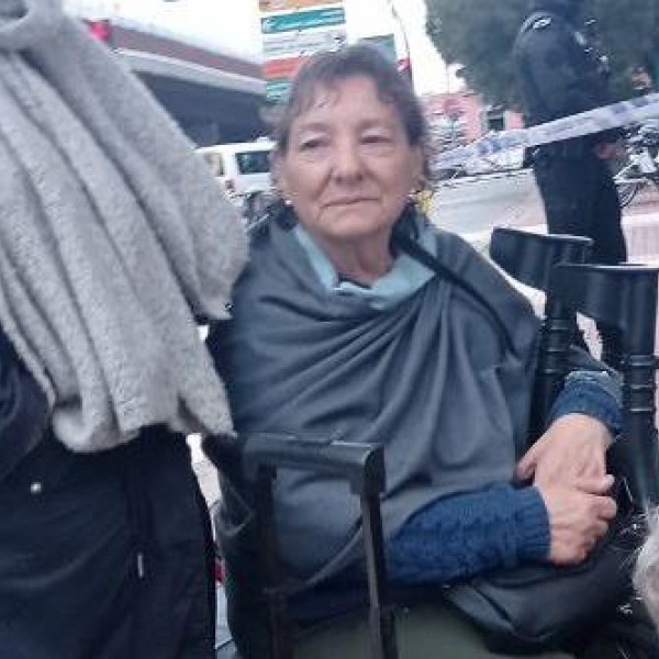 La señora Charo, en una silla en la calle mientras activistas de la PAH Vallecas sacan sus pertenencias de la casa tras su desalojo.