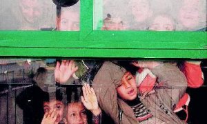 Niños palestinos miran por la ventana de una clase en una escuela de la ONU reabierta ayer.