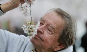 Un hombre oliendo una flor./REUTERS