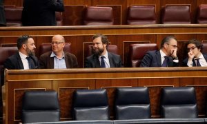 El presidente de VOX, Santiago Abascal, conversa con el diputado del PSC José Zaragoza en los escaños del Congreso de los Diputados. - EFE