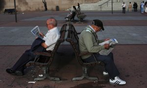 Unos pensionistas leen el periódico sentadados en un banco, en Madrid. REUTERS / Susana Vera