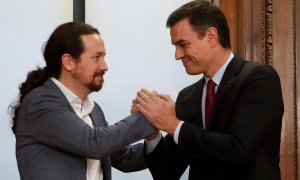 El candidato a la investidura, Pedro Sánchez (d), y el líder de Podemos, Pablo Iglesias (i), estrechan sus manos tras el acto de firma del acuerdo programático con las principales medidas que tomará el futuro Gobierno de coalición.EFE/JuanJo Martín