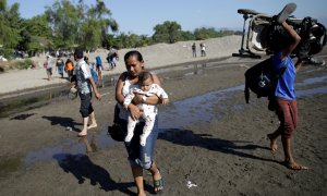 Migrantes de la caravana que viaja a Estados Unidos cruzando a la orilla guatemalteca del río en Ciudad Hidalgo, México. / Reuters