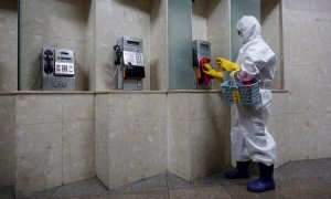 Un operario limpia los teléfonos de la estación de Gwanghwamun, en Seúl, Corea del Sur. - EFE