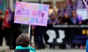 Vista de un menor con un cartel en el que se puede leer "El futuro es femenino" durante la manifestación con motivo del Día Internacional de la Mujer. EFE/ Ana F. Barredo