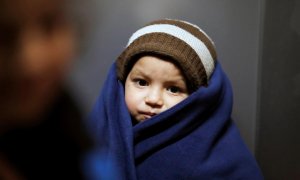 Un niño se tapa tras cruzar en patera la frontera hacia Lesbos.  REUTERS/Umit Bektas