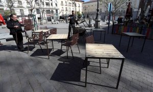 Varias personas recogen este viernes la terraza de un bar en la Plaza de Santa Ana, en el centro de Madrid. - EFE