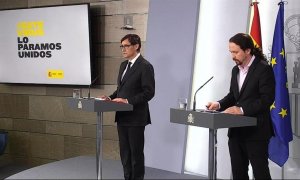 Captura de la señal institucional del Palcio de la Moncloa.- El vicepresidente de Asuntos Sociales y Agenda 2030, Pablo Iglesias (d), este jueves durante la rueda de prensa en el Palacio de la Moncloa, en la que ha comparecido junto al ministro de Sanida