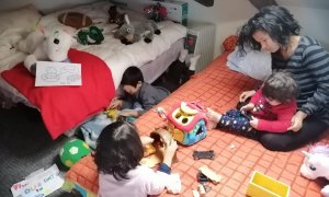 Carmen Nava, de 30 años, juega con sus hijos en la única habitación de su casa alquilada de 35 metros, en las que pasan el confinamiento cinco personas.-CEDIDA
