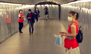 GRAFCAT5817. BARCELONA, 04/05/2020.- Voluntarias de la Cruz Roja reparte mascarillas en el Metro de Barcelona, este lunes, primer día en el que el uso de mascarillas en el transporte público es obligatorio, en el inicio de la fase 0 del plan de desescalad