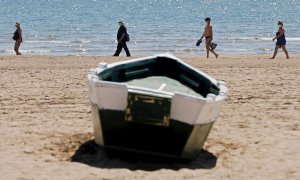 Cuatro personas disfrutan del buen tiempo y del calor en la playa de la Malvarrosa, el pasado viernes. EFE/Kai Försterling