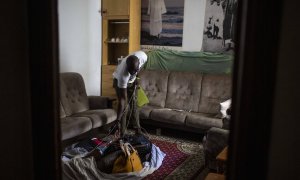 Samba, senegalés de 28 años, muestra el el salón de su casa de Lavapiés la manta con los bolsos que no ha podido vender en la calle durante el confinamiento decretado por el coronavirus.-  JAIRO VARGAS