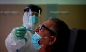 Una profesional sanitaria realiza una prueba PCR a un paciente. EFE/Enric Fontcuberta/Archivo