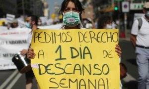Una mujer sujeta una pancarta en la que se lee 'Pedimos derecho a 1 día de descanso semanal' durante una manifestación de los médicos internos residentes (MIR) en Madrid. /Europa Press