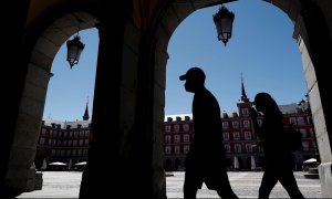 Dos turistas visitan la Plaza Mayor de Madrid, este sábado, día de la festividad de la Virgen de la Paloma. EFE/Mariscal
