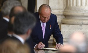 Juan Carlos I firma su abdicación, en una ceremonia en la Sala de Columnas del Palacio Real de Madrid, el 18 de junio de 2014. AFP/GERARD JULIEN