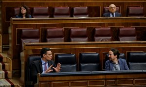 El presidente del Gobierno, Pedro Sánchez, conversa con el vicepresidente segundo, Pablo Iglesias,  durante una sesión de control al Gobierno en el Congreso de los Diputados. E.P./Pool