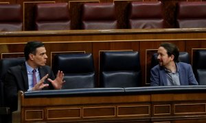 El presidente del Gobierno, Pedro Sánchez, conversa con el vicepresidente segundo, Pablo Iglesias,  durante una sesión de control al Gobierno en el Congreso de los Diputados. E.P./Pool